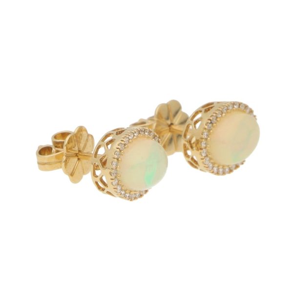 Opal and diamond cluster halo stud earrings in gold.