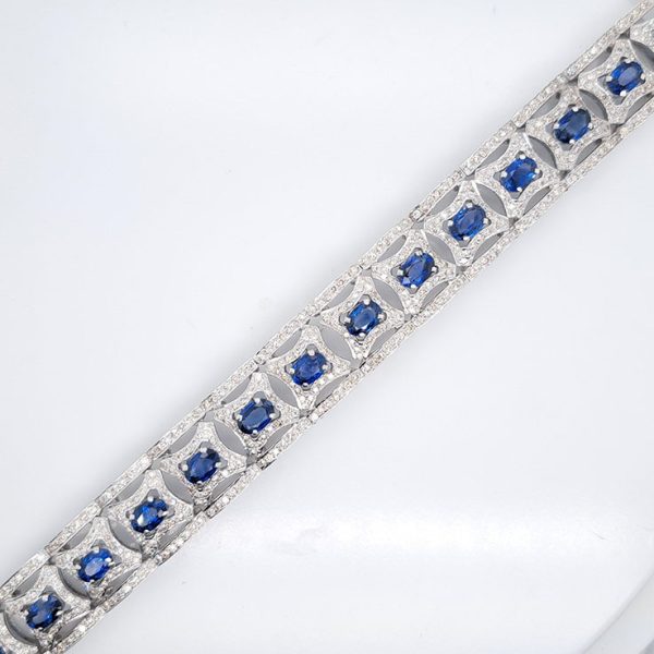 Art Deco Style 10ct Sapphire and Diamond Cluster Bracelet, oval blue sapphires within diamond surrounds edged top and bottom with diamond borders in 18ct white gold