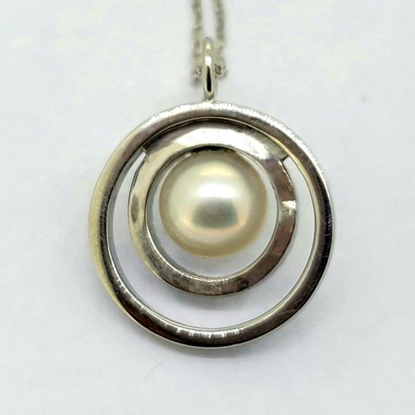 Contemporary Circular Pearl and Diamond Pendant, central pearl surrounded by a fixed diamond-set border and an outer polished gold border in 14ct white gold