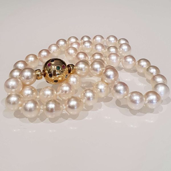 Vintage Italian Akoya Pearl Necklace, Akoya Japanese cultured pearls on 18ct gold ball clasp set with small rubies, sapphires and emeralds. Circa 1980s