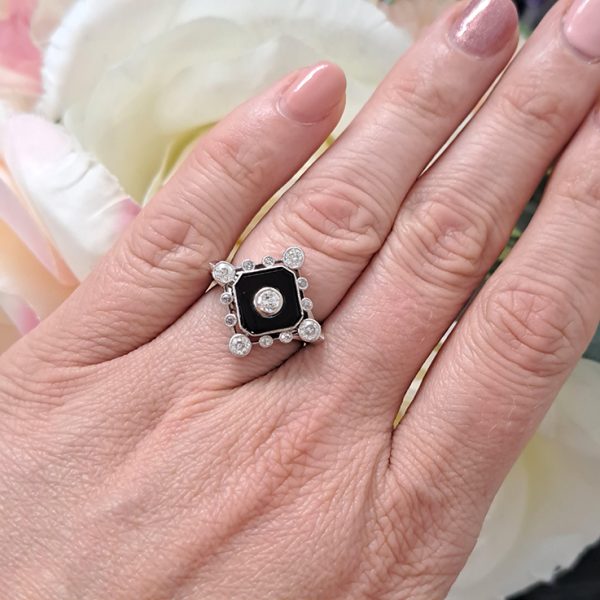 Late Art Deco Onyx and Diamond Cluster Ring in platinum and white gold. Circa 1930s