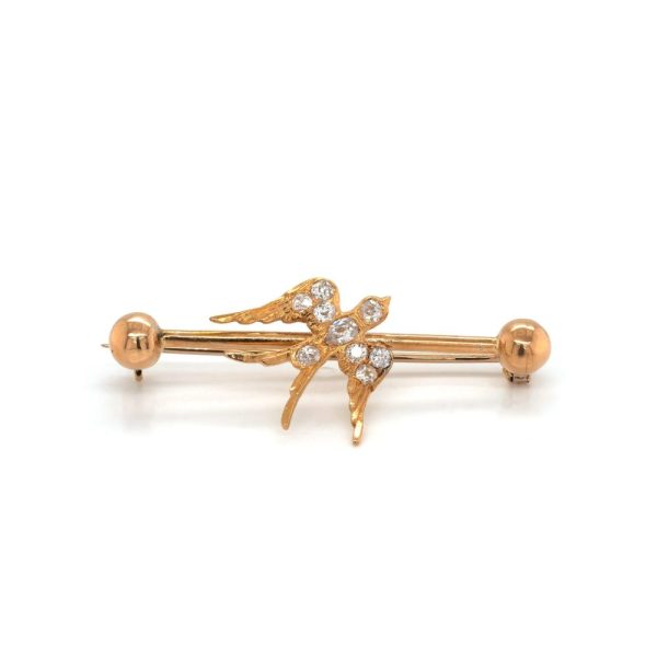 Diamond swallow bar bar brooch in yellow gold. 