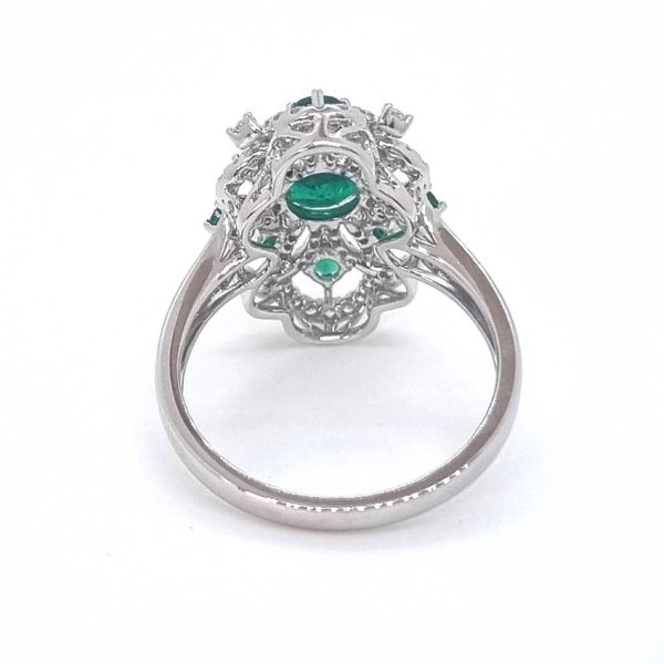 Decorative 1.13ct Emerald and Diamond Cluster Dress Ring, 1.13 carat emerald nestled within entwinned loop diamond surround with emerald accents in 18ct white gold