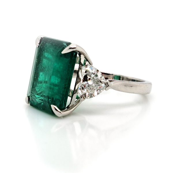 9ct Zambian Emerald and Heart Diamond Three Stone Ring with GIA Certificates, 9.08ct emerald-cut Zambian emerald flanked by GIA certified heart shaped diamonds in platinum