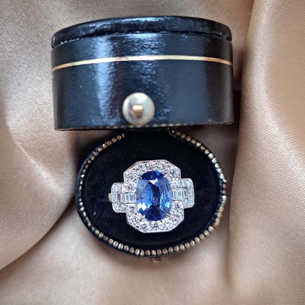 2ct Oval Sapphire and Diamond Cluster Ring, 2.02ct oval blue sapphire surrounded by diamonds with diamond buckle design shoulders