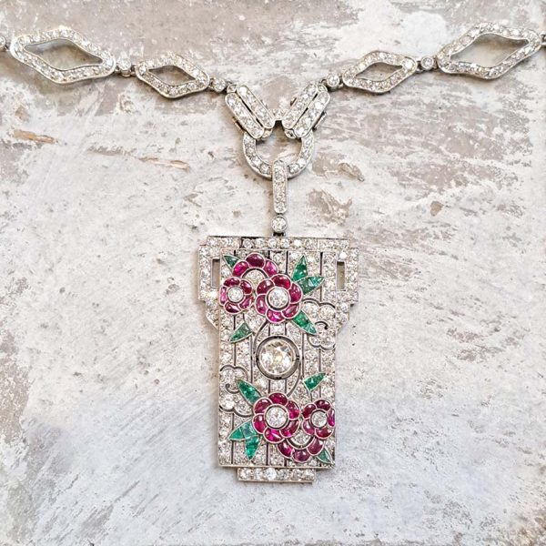 Art Deco Ruby Emerald Diamond Pendant Sautoir Necklace in Platinum, diamond sautoir necklace of alternating sized diamond-shaped links set with single-cut diamonds leading to detachable diamond, ruby and emerald set floral plaque pendant. Circa 1925