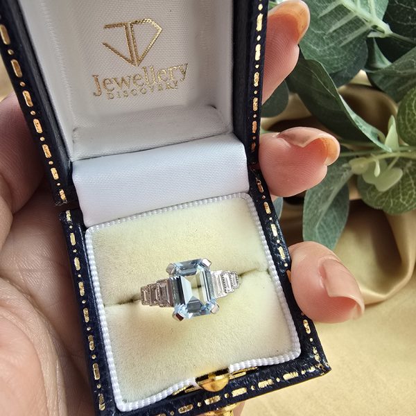 1.20ct Aquamarine and Diamond Engagement Ring in Platinum, 1.20ct emerald-cut aquamarine flanked by graduated stepped baguette-cut diamonds to the sides