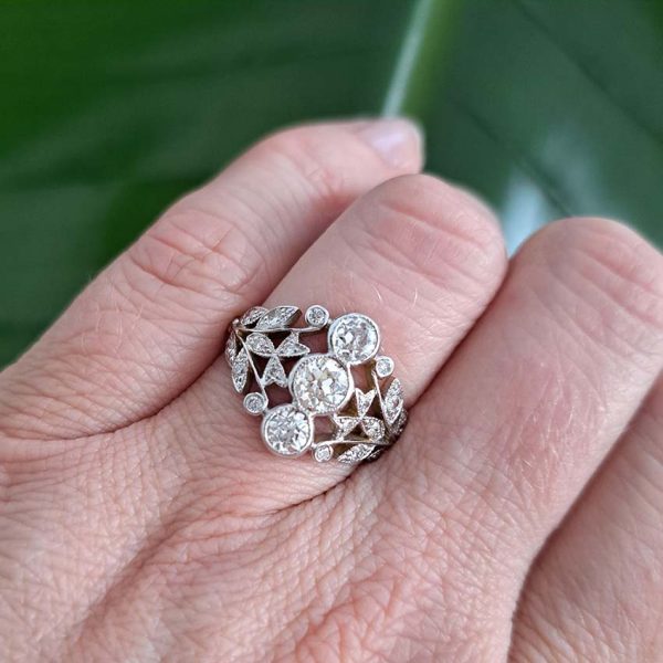 Diamond Trilogy Cluster Dress Ring, 1.51 carat total, decorative diamond dress ring featuring three central diamonds vertically bezel set and flanked by tapered pierced shoulders of leaf design studded with diamonds in 18ct yellow and white gold