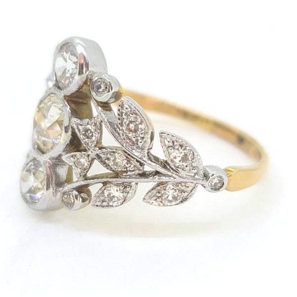 Diamond Trilogy Cluster Dress Ring, 1.51 carat total, decorative diamond dress ring featuring three central diamonds vertically bezel set and flanked by tapered pierced shoulders of leaf design studded with diamonds in 18ct yellow and white gold