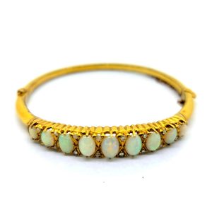 Opal and Diamond Yellow Gold Bangle Bracelet, 18ct yellow gold hinged bangle bracelet set with gently graduating oval cabochon opals with diamond accents