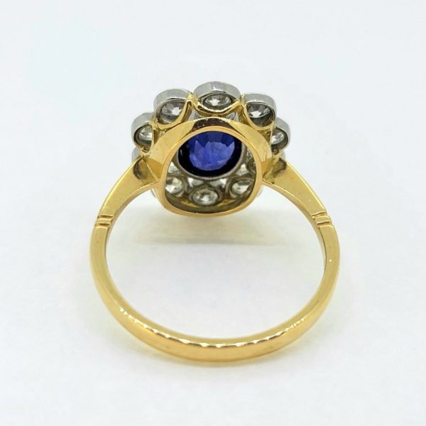 1.35ct Oval Sapphire and Diamond Floral Cluster Ring, oval-cut sapphire surrounded by 0.90cts round brilliant-cut diamonds in platinum to 18ct yellow gold