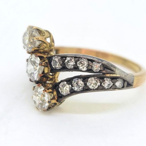 Victorian Antique Diamond Three Stone Banded Ring, diamond trilogy vertically set in asymmetrical design flanked by diamond banded shoulders in silver upon 18ct yellow gold