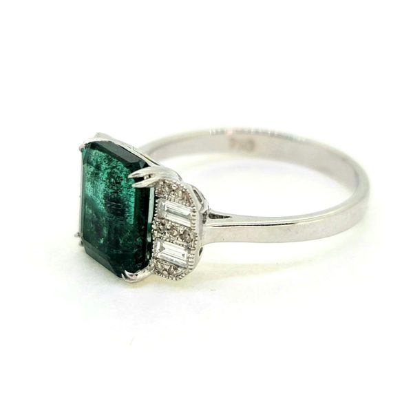 2.85ct Emerald and Diamond Engagement Ring, 2.85 carat emerald flanked by alternating baguette-cut and brilliant-cut diamonds in 18ct white gold