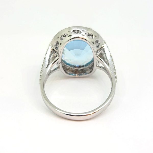 6.80ct Oval Aquamarine and Diamond Cluster Statement Cocktail Ring, large oval-cut aquamarine of 6.80 carats surrounded by diamond halo border in 18ct white gold with diamond-set split shoulders