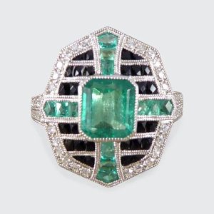 Emerald, onyx and diamond cluster ring in platinum.