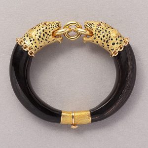 Vintage Gold Panther Head and Wood Bangle Bracelet, single mobile gold ring held in the mouths jaws of two 18ct yellow gold panther heads with ruby eyes and black enamel spots with hidden clasp and safety clasp at the back of the bangle