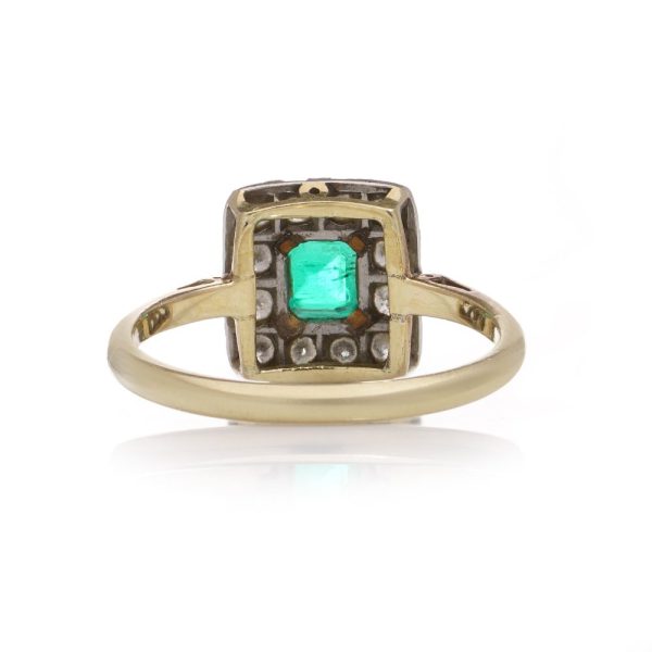 Emerald and diamond cluster ring in gold and platinum.