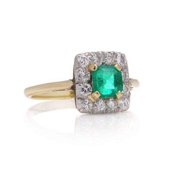 Emerald and diamond cluster ring in gold and platinum.