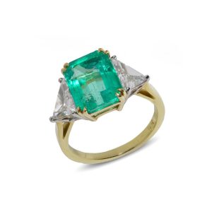 Emerald and diamond three stone ring in gold and platinum.