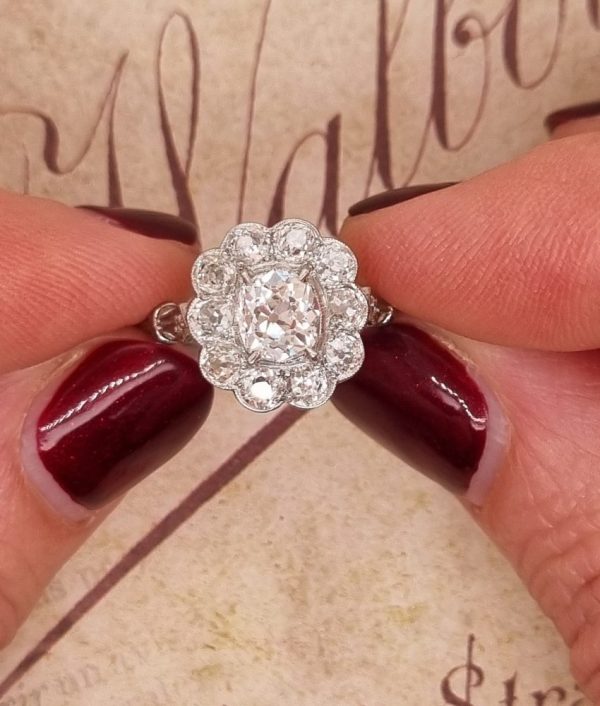 Vintage old cut diamond cluster ring with cushion shape old mine cut 0.90 carat diamond in the centre surrounded by 10 diamonds totaling 1.15 carats set in platinum.