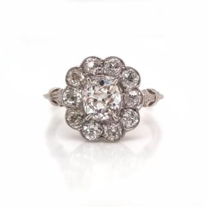 Vintage old cut diamond cluster ring with cushion shape old mine cut 0.90 carat diamond in the centre surrounded by 10 diamonds totaling 1.15 carats set in platinum.