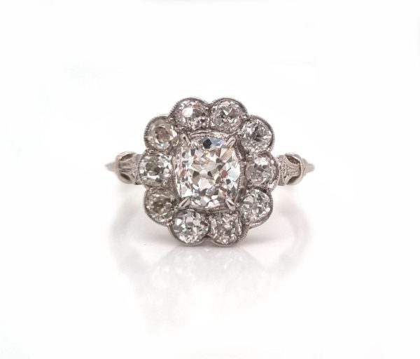 Vintage old cut diamond cluster ring with cushion shape old mine cut 0.90 carat diamond in the centre surrounded by 10 diamonds totaling 1.15 carats set in platinum.