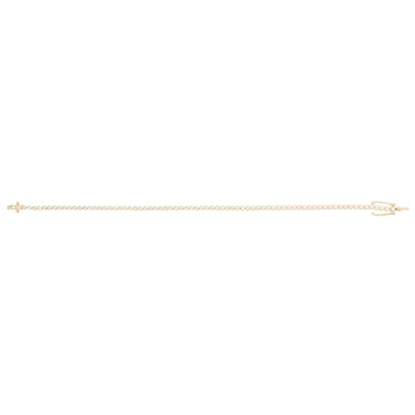 A contemporary made 1.08ct diamond bezel set line bracelet crafted in 18ct yellow gold with 75 round brilliant cut diamonds.