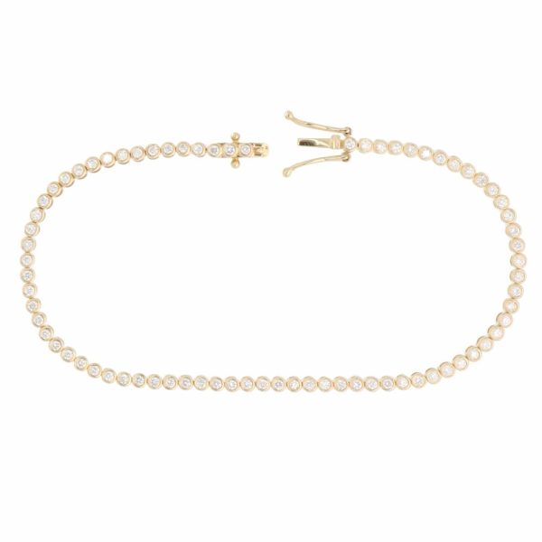 A contemporary 1.08ct diamond bezel set line bracelet crafted in 18ct yellow gold with 75 round brilliant cut diamonds.