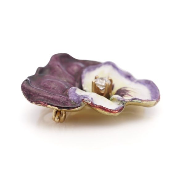 Gold flower brooch with enamel and an old-European cut diamond.