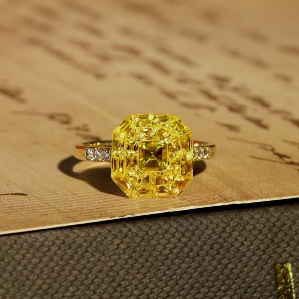 Yellow Sapphire Octagonal Cluster Solitaire Engagement Ring, 5.27cts yellow sapphires arranged in an invisible setting to produce an octagonal shaped design in 14ct yellow gold with diamond set shoulders