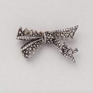 Antique 18ct gold bow shaped brooch open worked embellished with small rose cut diamonds, Circa 1880, France.