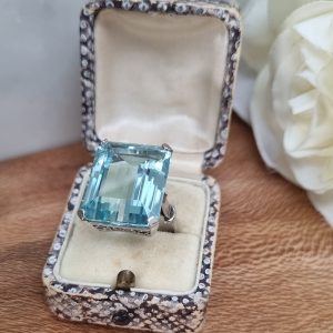 Art Deco 23cts Aquamarine Cocktail Ring in Platinum, single stone 23.18ct emerald-cut aquamarine four-claw set in handmade platinum setting with scroll wirework. Circa 1930