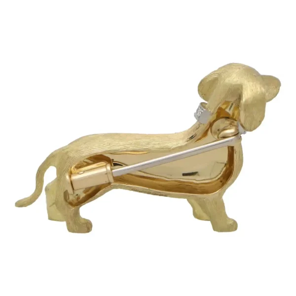 Diamond and ruby Dachshund dog brooch in gold.