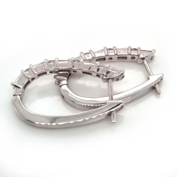 Horseshoe 1.31ct Brilliant and Baguette Diamond Hoop Earrings, 1.31 carats of alternating baguette and round brilliant diamond set horseshoe-shaped hoop earrings in 18ct white gold