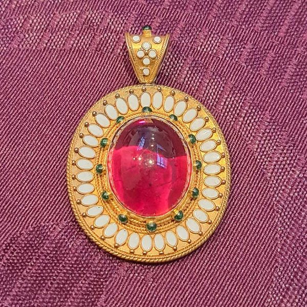 Antique Archaeological Revival Garnet Enamel and Gold Pendant, yellow gold pendant with large oval cabochon-cut garnet accented with white enamel and green enamel decorated surround