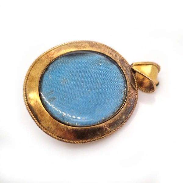 Antique Archaeological Revival Garnet Enamel and Gold Pendant, yellow gold pendant with large oval cabochon-cut garnet accented with white enamel and green enamel decorated surround