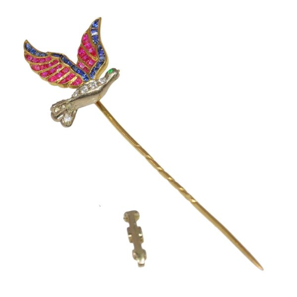 Vintage flying bird tiepin with multiple gemstones in gold.