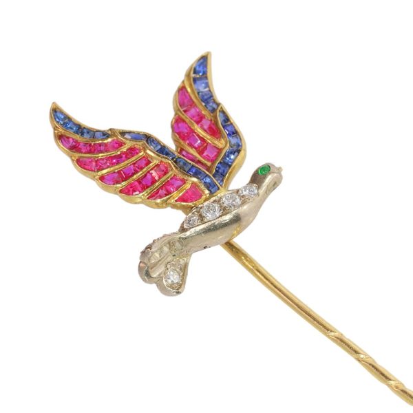 Vintage flying bird tiepin with multiple gemstones in gold.
