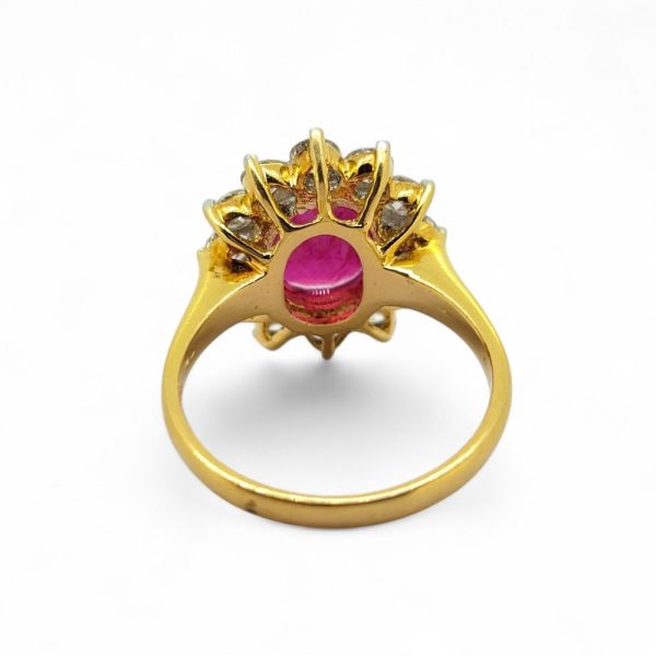 3.30ct Oval Ruby and Diamond Cluster Engagement Ring, 3.30ct oval-cut ruby surrounded by 1.24cts sparkling round brilliant-cut diamonds claw set and mounted in 18ct yellow gold