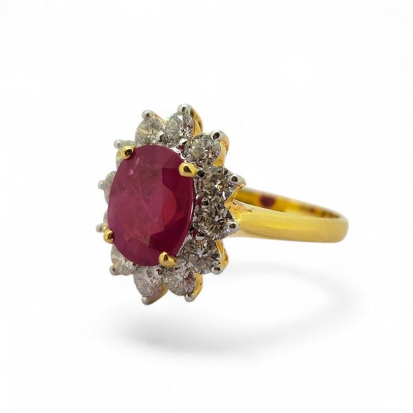 3.30ct Oval Ruby and Diamond Cluster Engagement Ring, 3.30ct oval-cut ruby surrounded by 1.24cts sparkling round brilliant-cut diamonds claw set and mounted in 18ct yellow gold