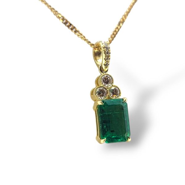 1.72ct Emerald and Diamond Pendant with Chain, 1.72ct emerald-cut emerald suspended from diamond set bail with trio of diamonds set to the head of the emerald in 18ct yellow gold