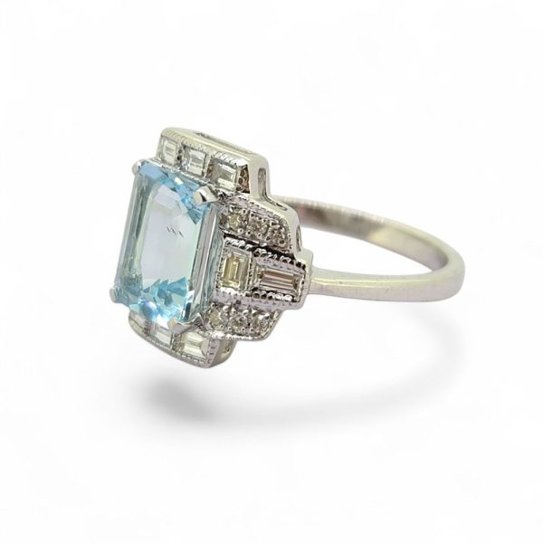 2ct Aquamarine and Diamond Cluster Dress Ring, 2.11ct emerald-cut aquamarine surrounded by brilliant and baguette-cut diamonds in geometric design in 18ct white gold