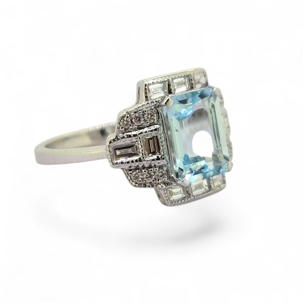 2ct Aquamarine and Diamond Cluster Dress Ring, 2.11ct emerald-cut aquamarine surrounded by brilliant and baguette-cut diamonds in geometric design in 18ct white gold