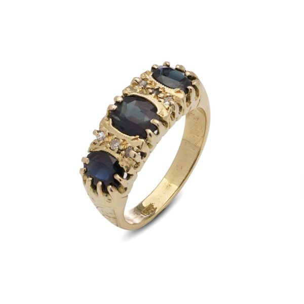 Vintage three stone sapphire ring with diamonds in gold.