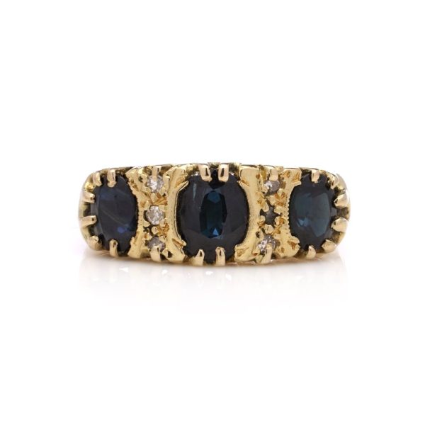 Vintage three stone sapphire ring with diamonds in gold.