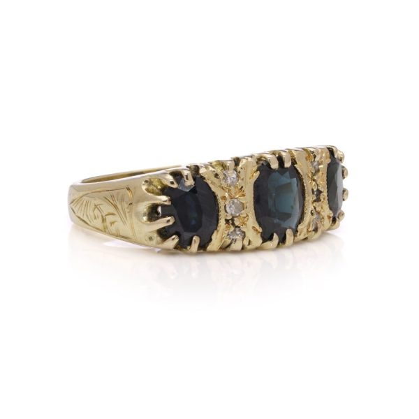 Vintage three stone sapphire ring with diamonds in gold.