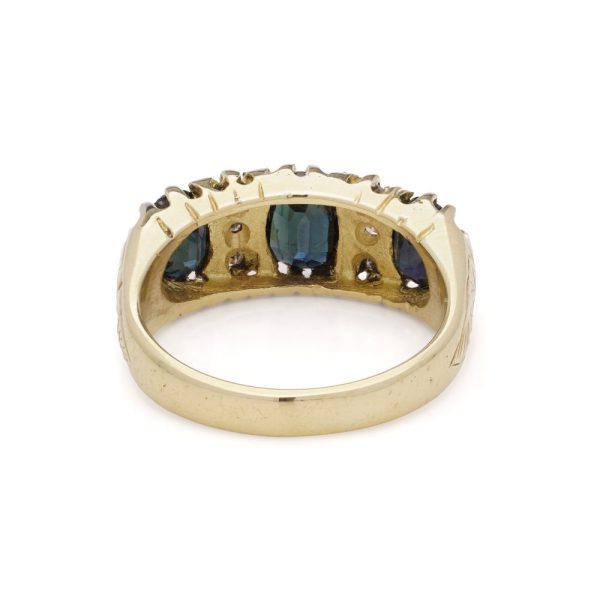 Vintage three stone sapphire ring with diamonds in gold.