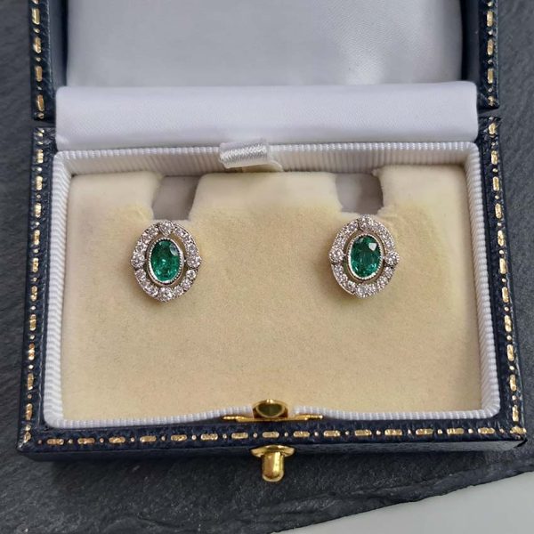 Contemporary Emerald and Diamond Oval Cluster Stud Earrings, 1.55ct emeralds with fixed border of diamonds with four focal at compass points in 18ct gold