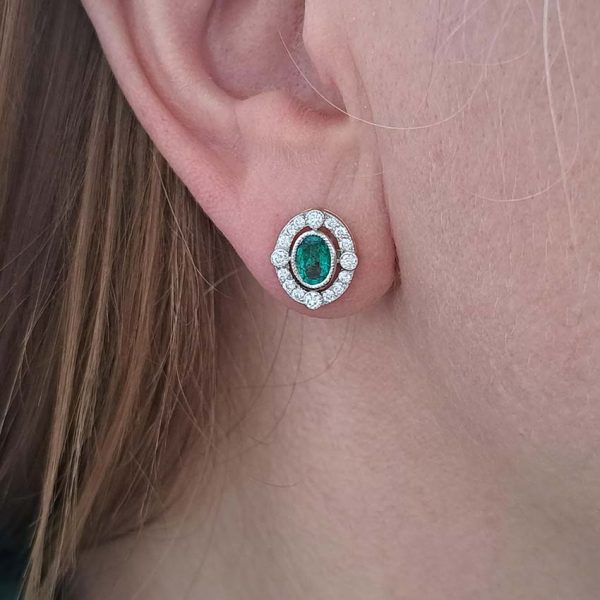 Contemporary Emerald and Diamond Oval Cluster Stud Earrings, 1.55ct emeralds with fixed border of diamonds with four focal at compass points in 18ct gold