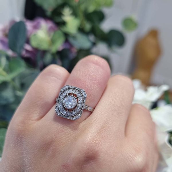 Art Deco Old Cut Diamond Cluster Tablet Plaque Ring, 0.55ct old cut diamond within 0.32ct oval halo and diamond set cut corners of an oblong head in platinum. Circa 1920s